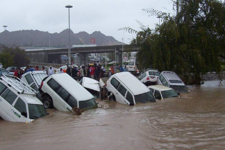 車主們在路旁看著愛車被雨水掩埋，但打完電話后大家卻笑了起來